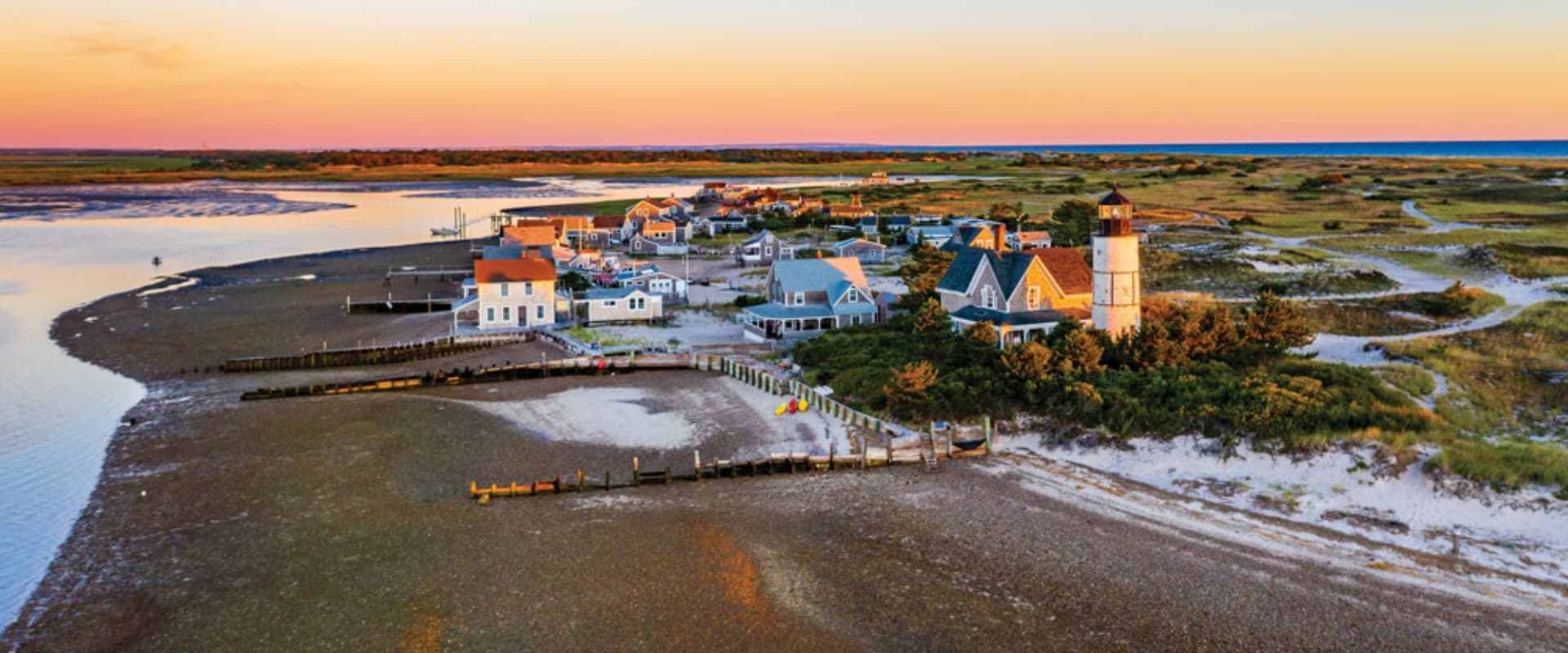 An aerial view of a small beachfront town at sunset.