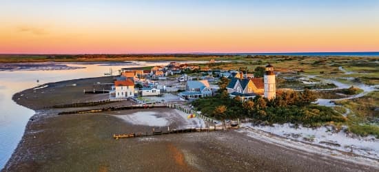 An aerial view of a small beachfront town at sunset.