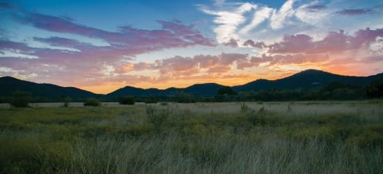 The sun setting below mountains.