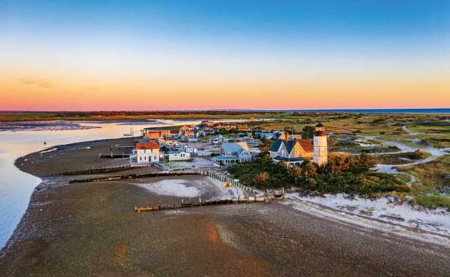 An aerial view of a small beachfront town at sunset.