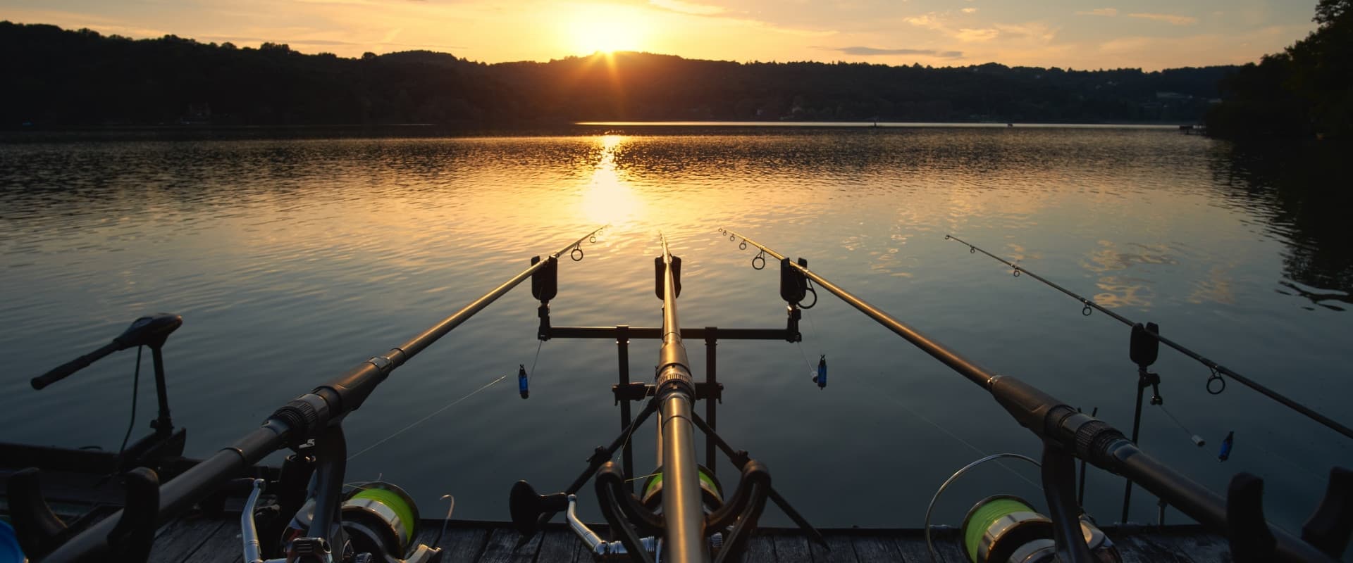 Two fishing rods on a lake at sunset