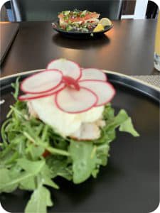 two plates across from each other with greens and other colorful food