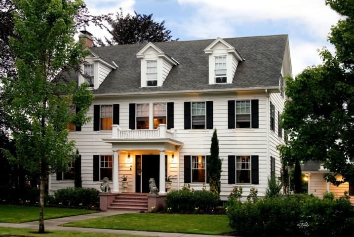 Front view of A' Tuscan Estate with porch lights on.