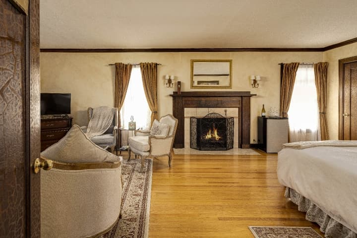 Tuscan Suite view from the entry door. Sitting area, fireplace and king bed.
