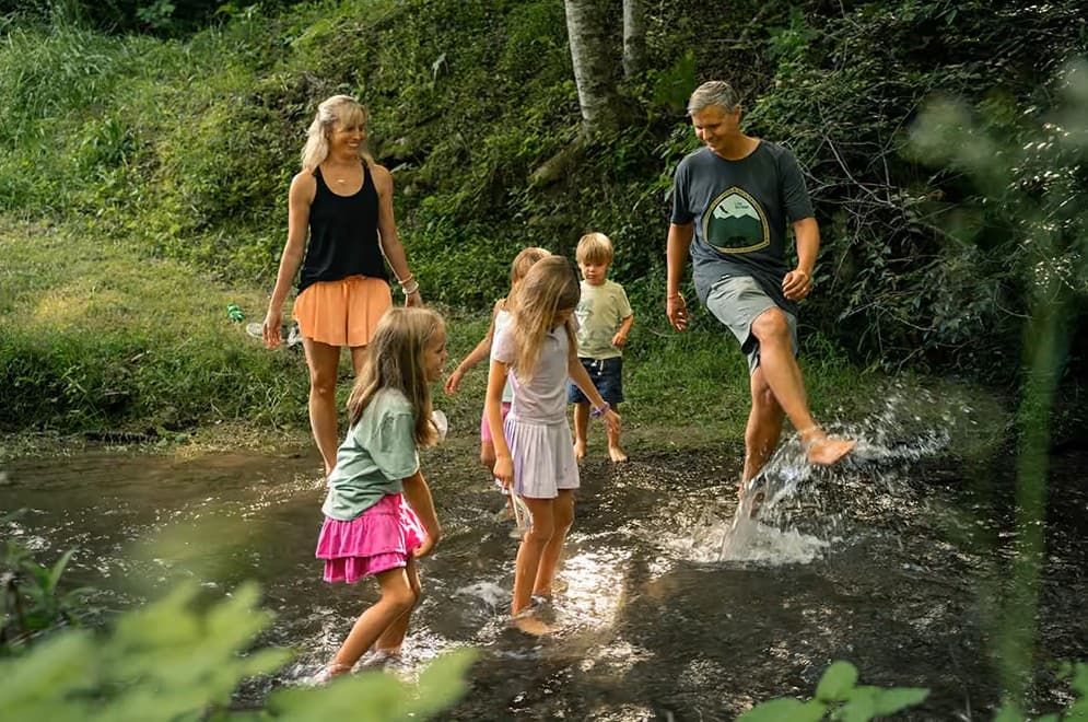 family playing in creek