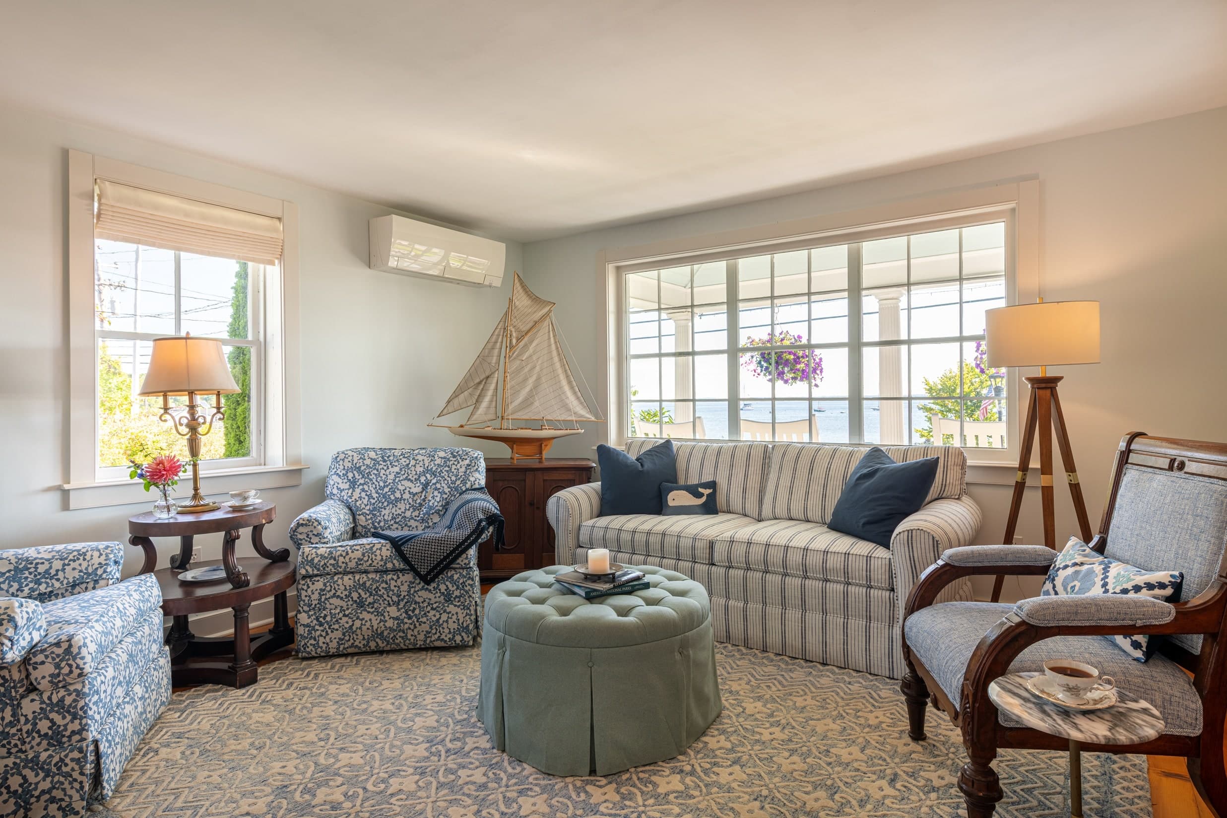 Living area in one of the suites at the Spouter Inn Bed and Breakfast; comfortable looking couch and chairs set against a window with a view.