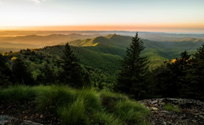 a scenic view of a mountain range at sunset