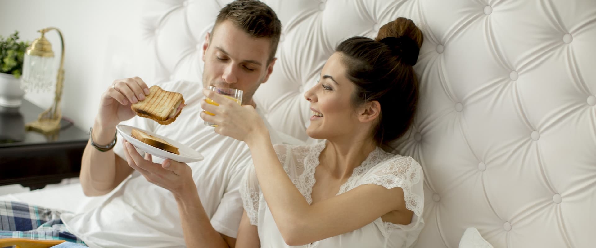 A couple enjoys breakfast in bed