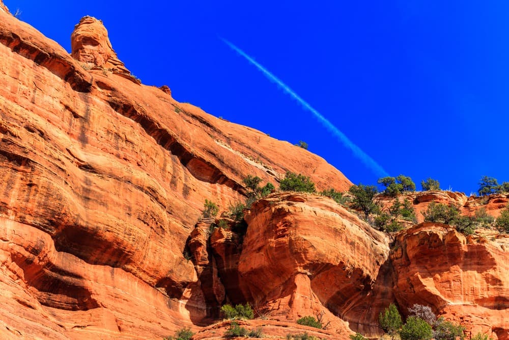 View from the ground looking up at Boynton Canyon with a blue sky behind it