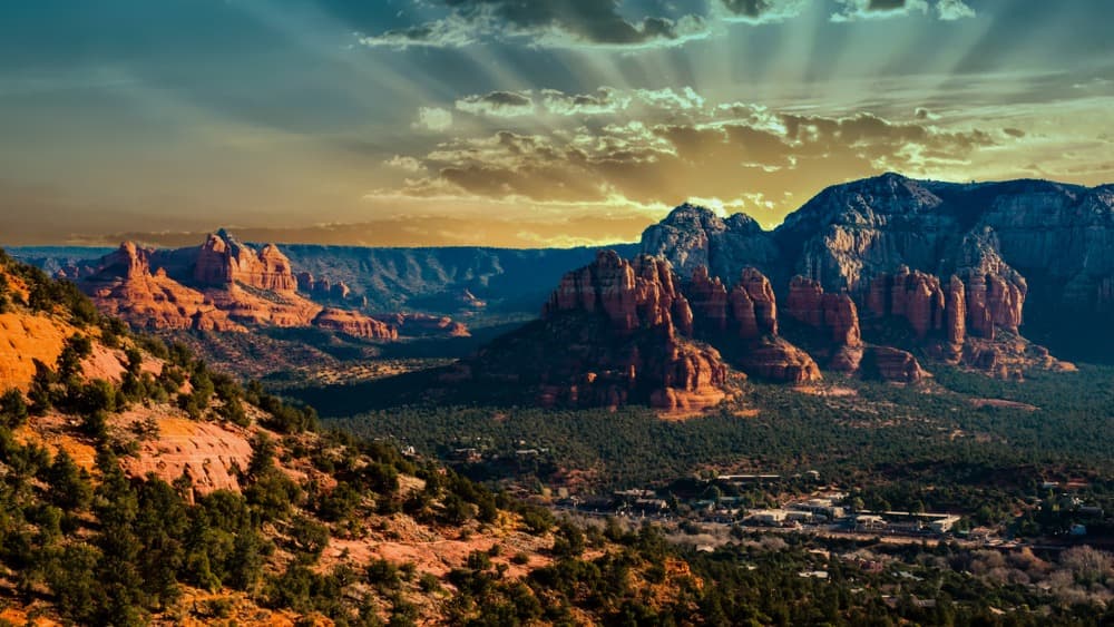 View of geological formations with a sunrise behind the mountains in the distance