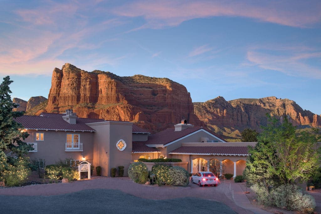 Exterior view of Canyon Villa Inn in Sedona with sunset in the background