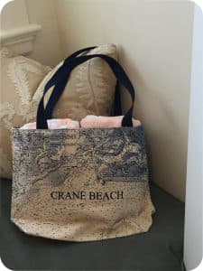 Beach back with two towels and the words "Crane Beach" on the outside