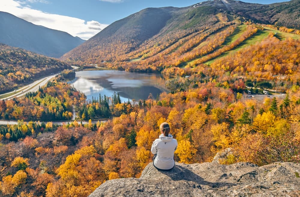 A woman hiking the Artists Bluff Trail at Franconia Notch State PArk in New Hampshire