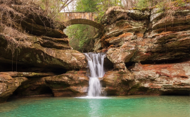 An outdoor waterfall descending into a small lake.