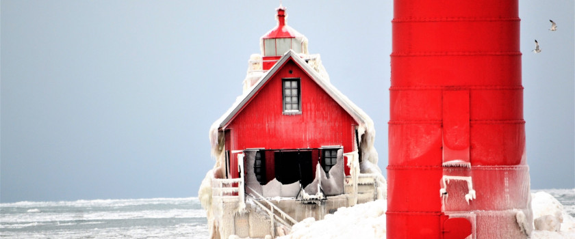 A red lighthouse on Lake Michigan