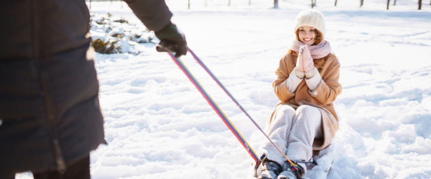 A woman being pulled on a sled in the snow