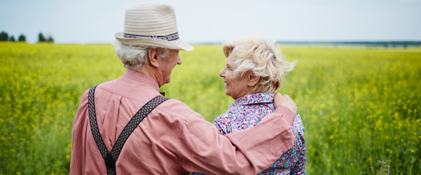 An affectionate older couple in a green meadow