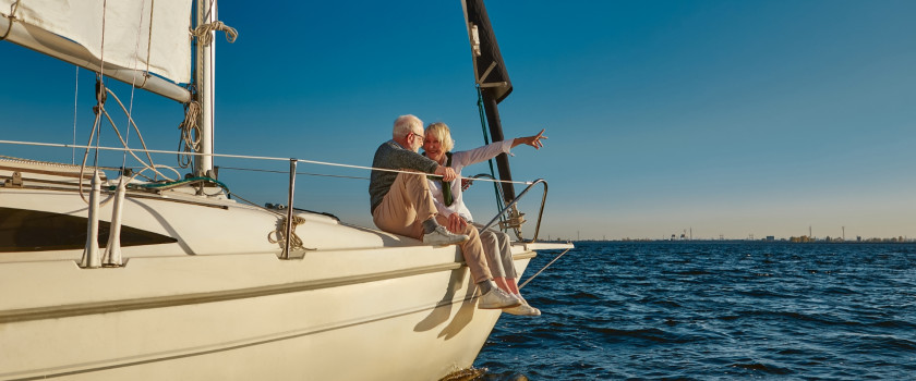 Retired couple sitting on the bow of a boat.