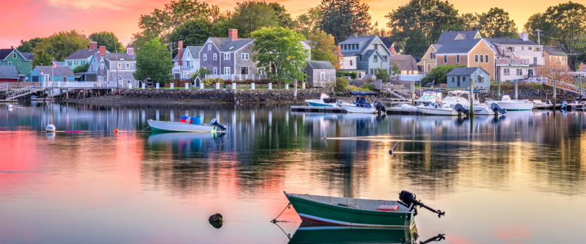 Boats docked on the water in Portsmouth, New Hampshire at sunset.