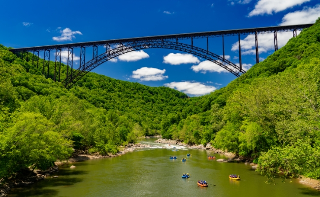 kayaking down a river under a bridge