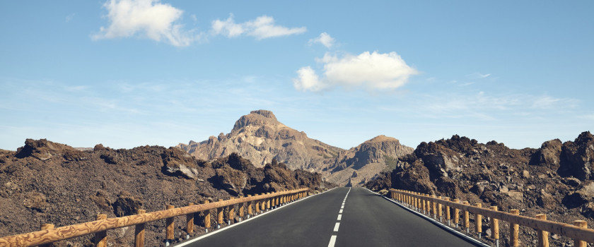 Open highway with rocky cliffs in the distance