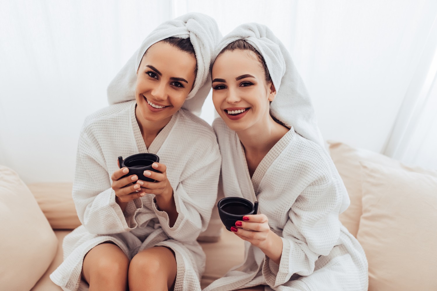 Two women in bathrobes relaxing at the spa.