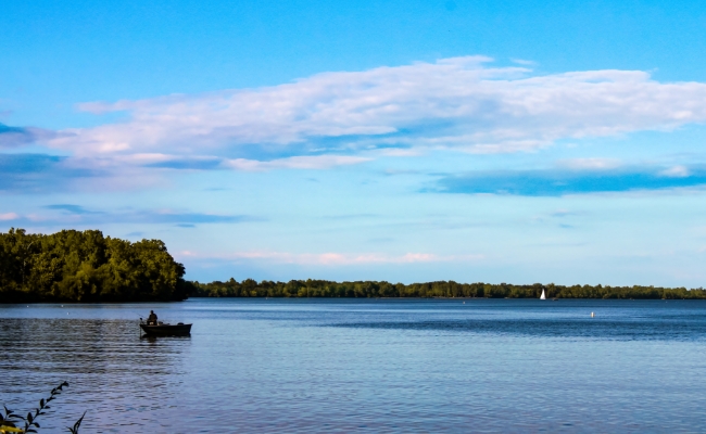 A fisherman in a canoe on a lake