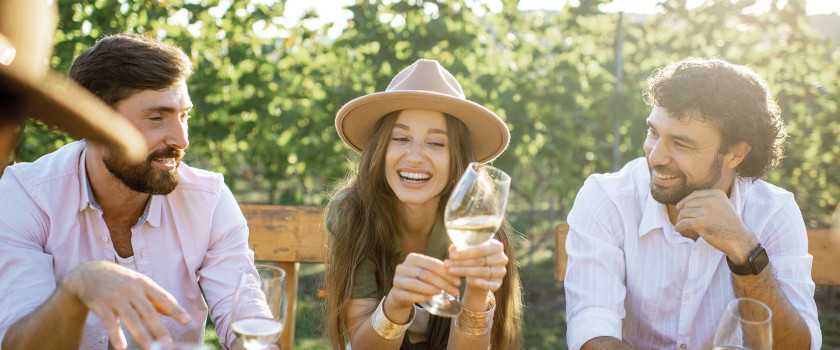 Friends Wine Tasting during a weekend getaway from New York City holding a wine glass and laughing