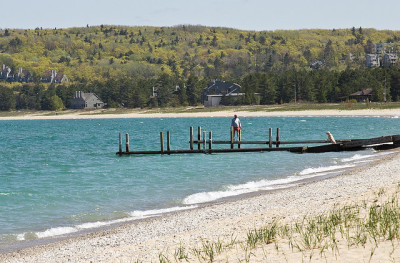 man walking on a dock in lake michigan near glen arbor