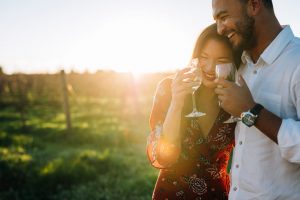 couple laughing and drinking wine outdoors; romantic things to do in virginia