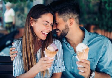 Happy young couple having date and eating ice cream