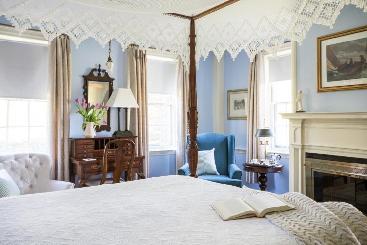 candleberry inn room feature blue walls, four poster bed with white lace canopy blue interior decor
