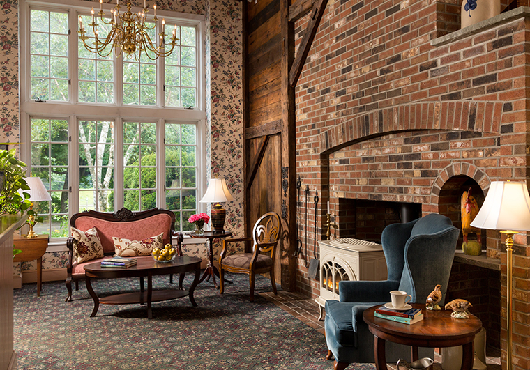 Chesterfield Inn parlor with brick fireplace and picture window looking over gardens