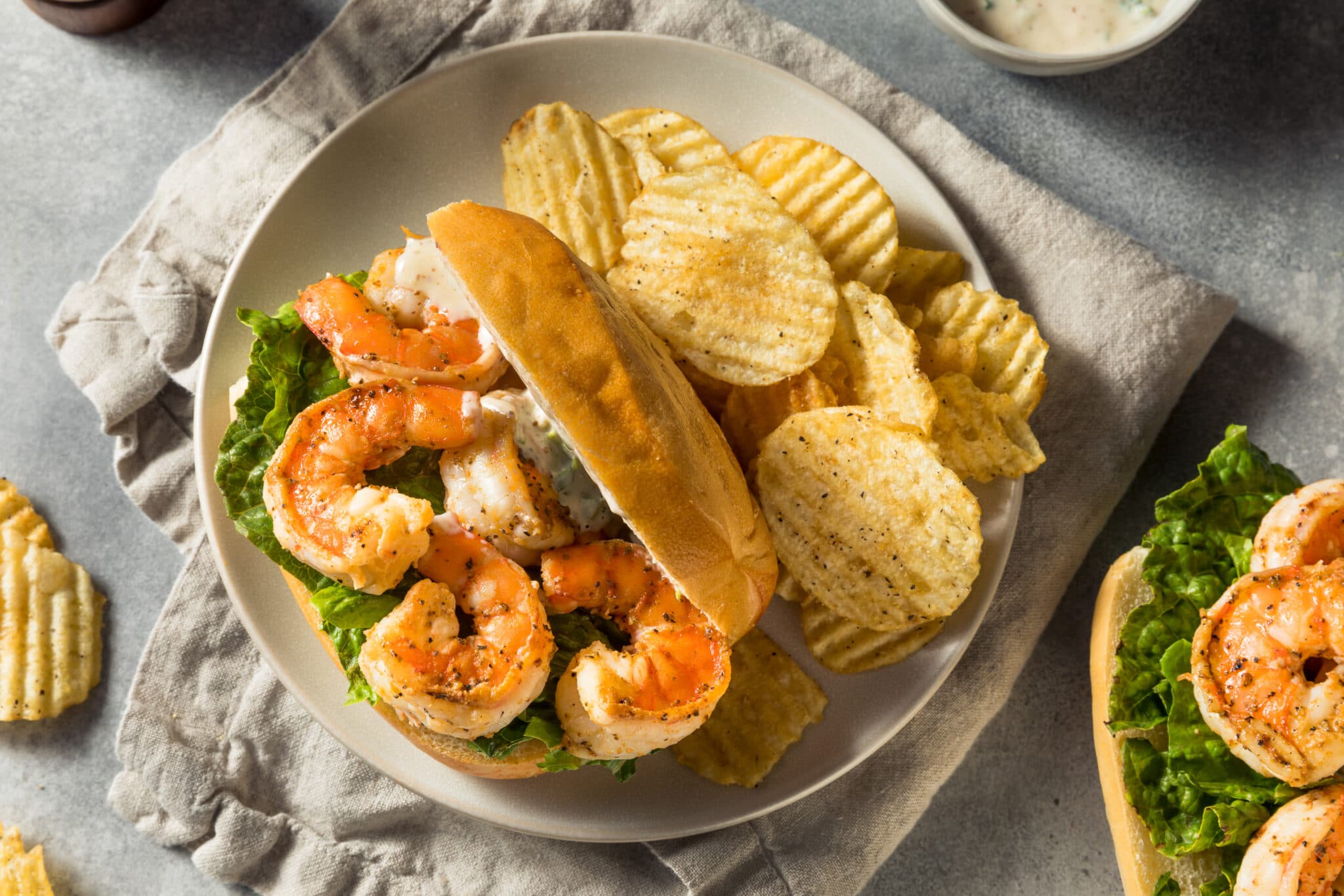 shrimp po boy sandwich plated with chips