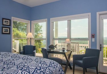 bedroom with blue walls and mountain views inn at riverbend