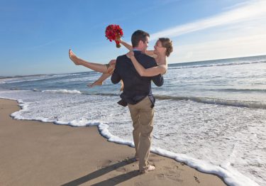 Wedding couple standing in surf in Half Moon Bay