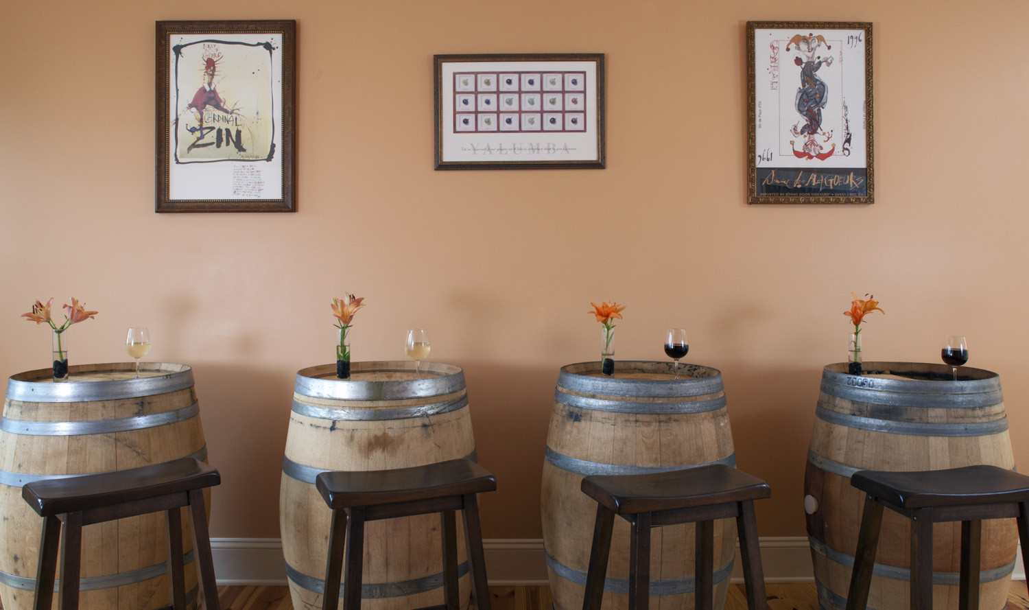 Arcady's barrel room with stools in front of barrels topped with fresh flowers and wine glasses