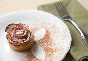 Pretty Pastry Hawthorne Inn pastry in the shape of a rose and cinnamon outlines in the shape of leaves sprinkled around the pastry