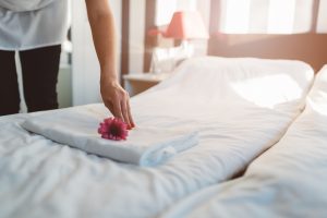 making a bed and putting flower on towel