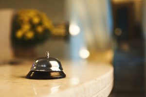 Hotel accommodation call bell on reception desk, contemporary interior, copy space