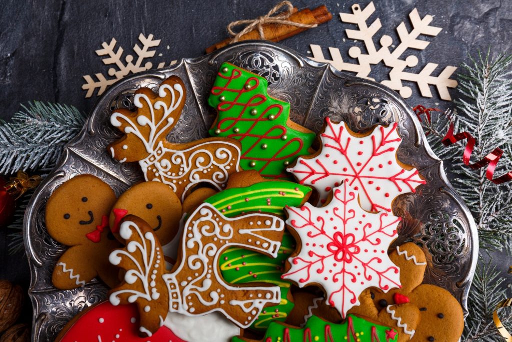 Beautiful and tasty Christmas cookies of different shapes and decorated with colored sugar icing. View from above. Indoors.
