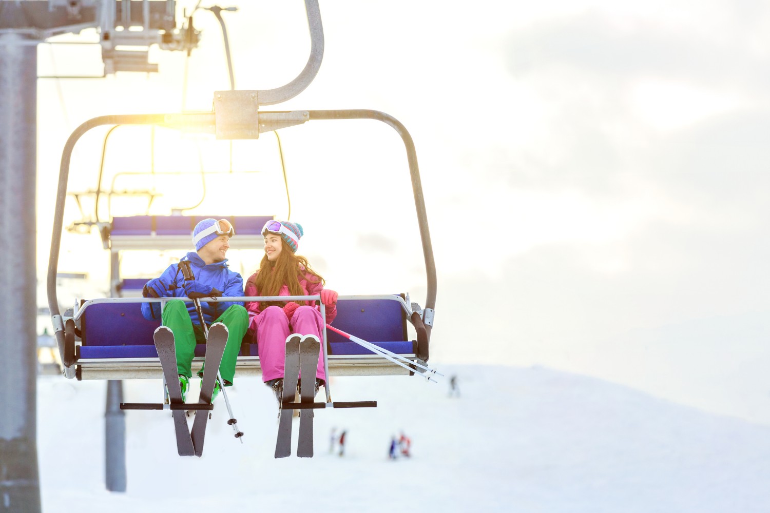 Young couple with skis outdoors on the ski lift 