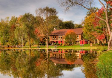 stone mansion with lake and autumn trees