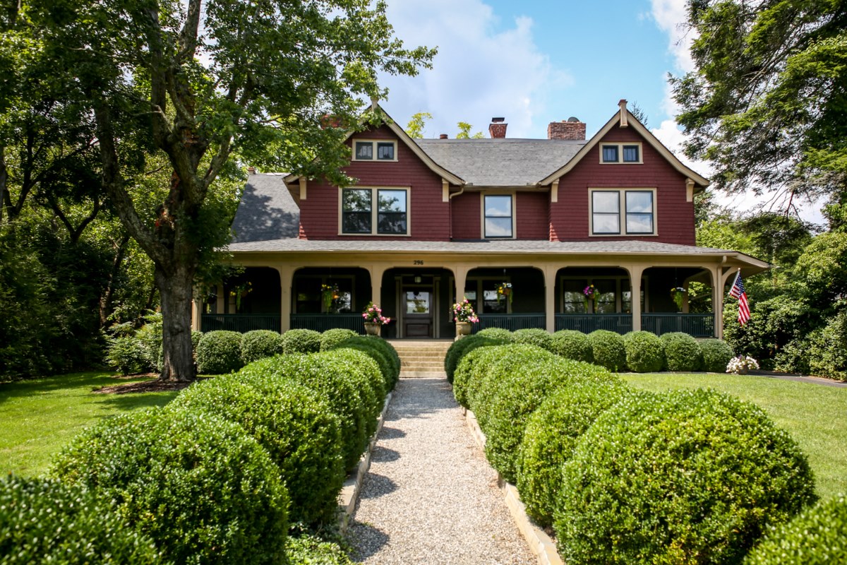 exterior image of 1900 inn on montford, with boxwood hedges