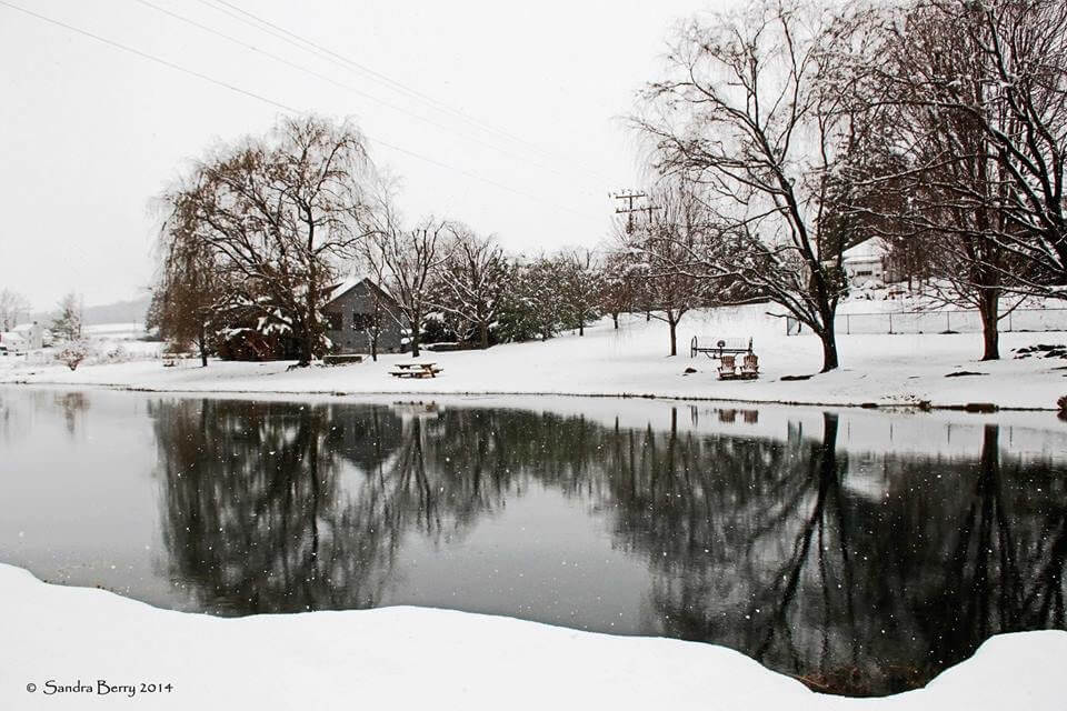 view of 1 acre pond in winter with snow covered grounds