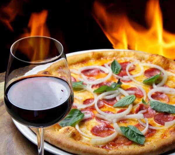 Pizza and wine by fireplace