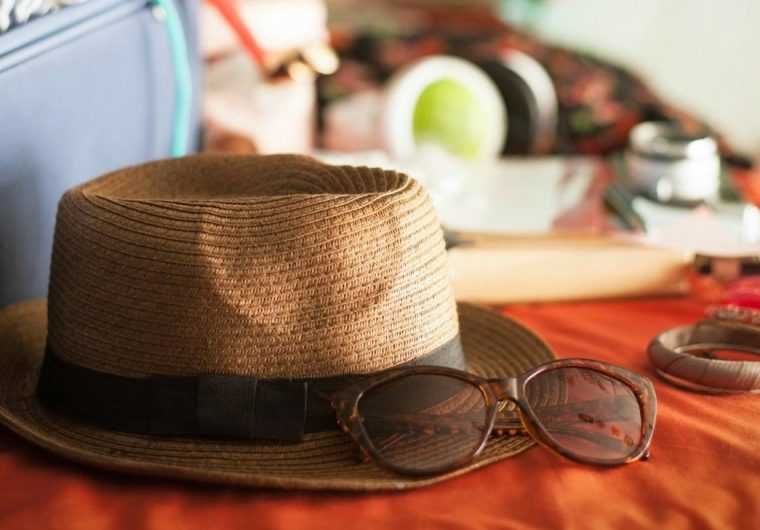 hat and sunglasses on bed