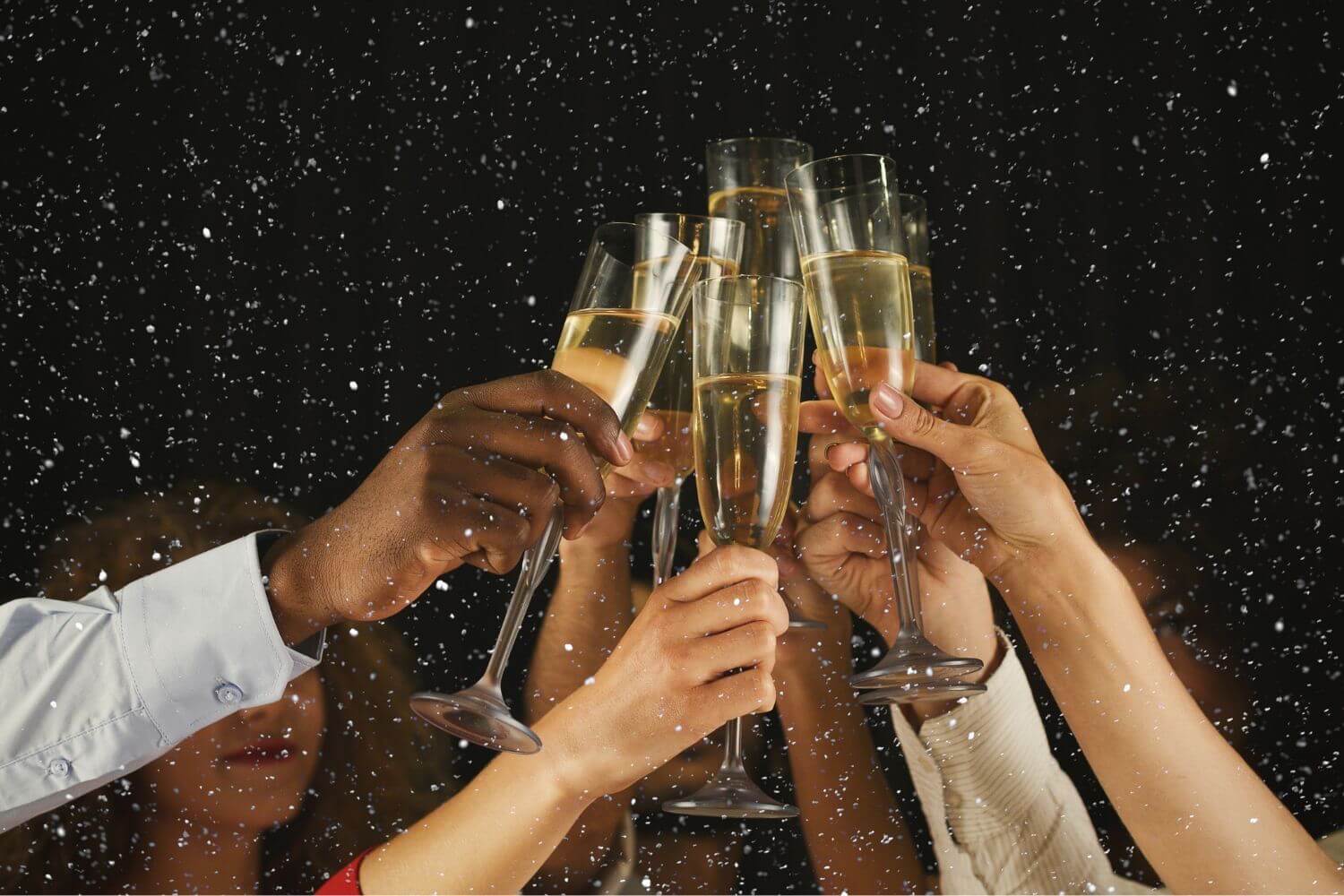 group of people toasting champagne glasses under the stars