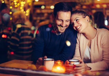 Romantic young couple dating in pub at night