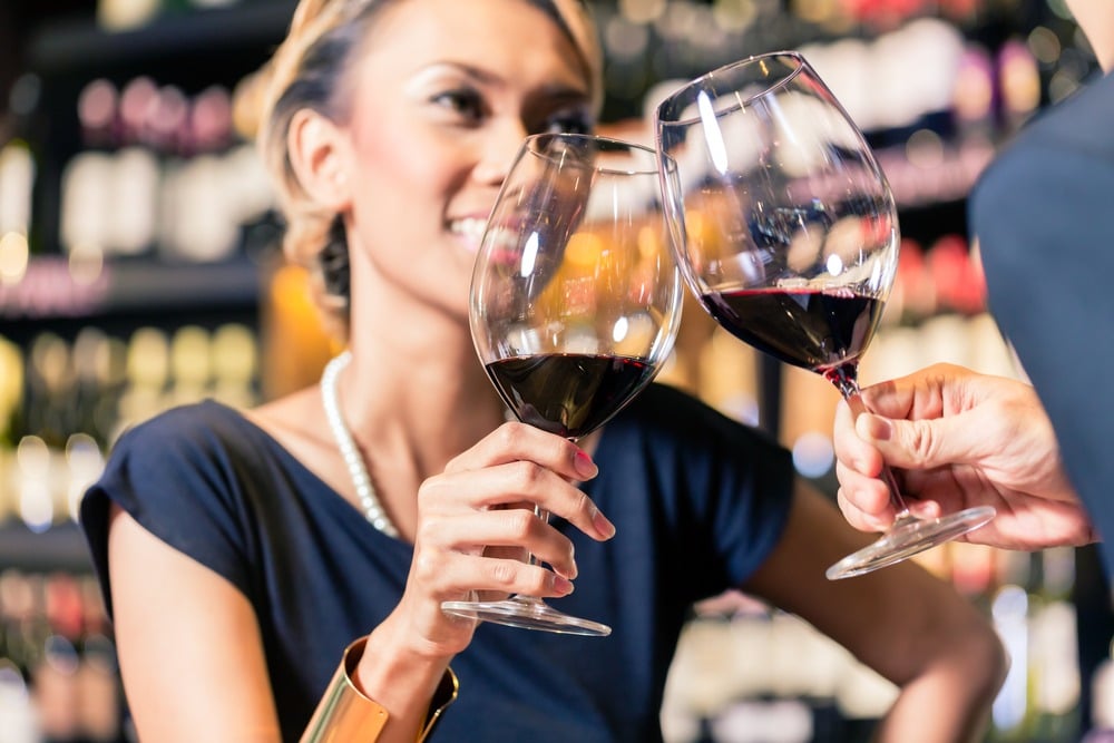 couples cheering with two glasses of red wine